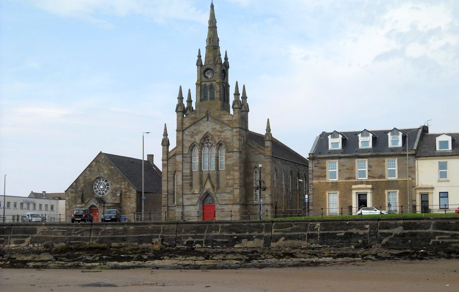 Barony St.John's Church on waterfront from South Bay Beach in Ardrossan on the Ayrshire Coast of Scotland